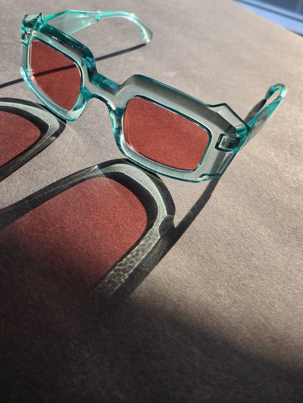 Transparent Teal Frame Sunglasses with Red Lenses